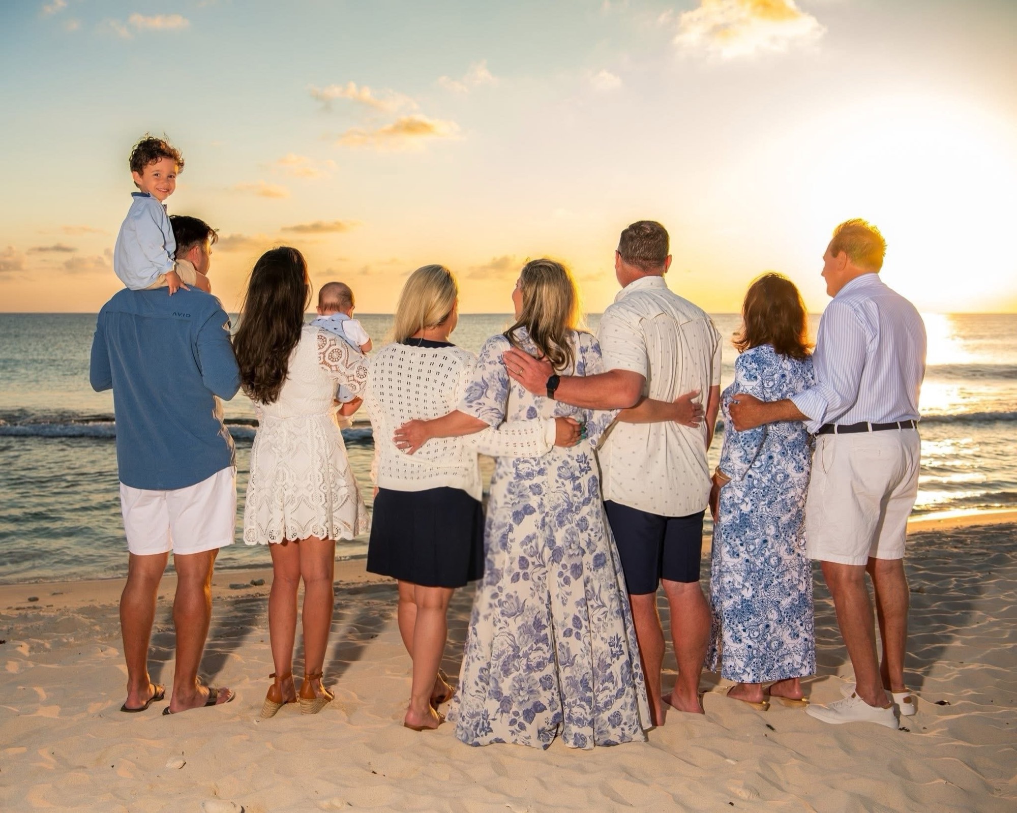 A family gathered on the beach at sunset in the Cayman Islands.